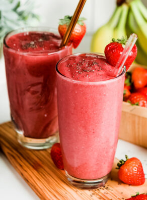 Strawberry banana smoothie recipe in pint glass with straw.