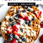 homemade vegan waffles topped with coconut whipped cream and fresh berries.