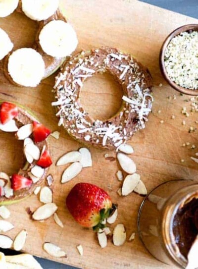 healthy snacks for weight loss including apple rings with nut butter and fruit toppings.