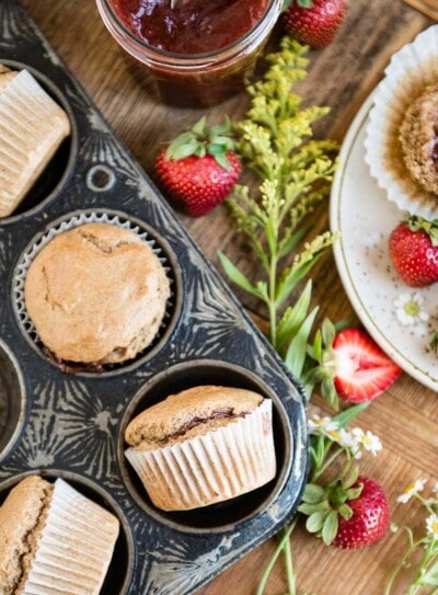 a pan full of strawberry jam-filled vegan muffins