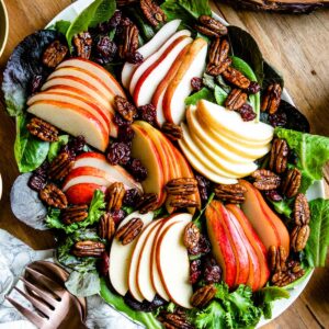 A vibrant and colorful fall harvest salad with candied pecans, ready to be served.
