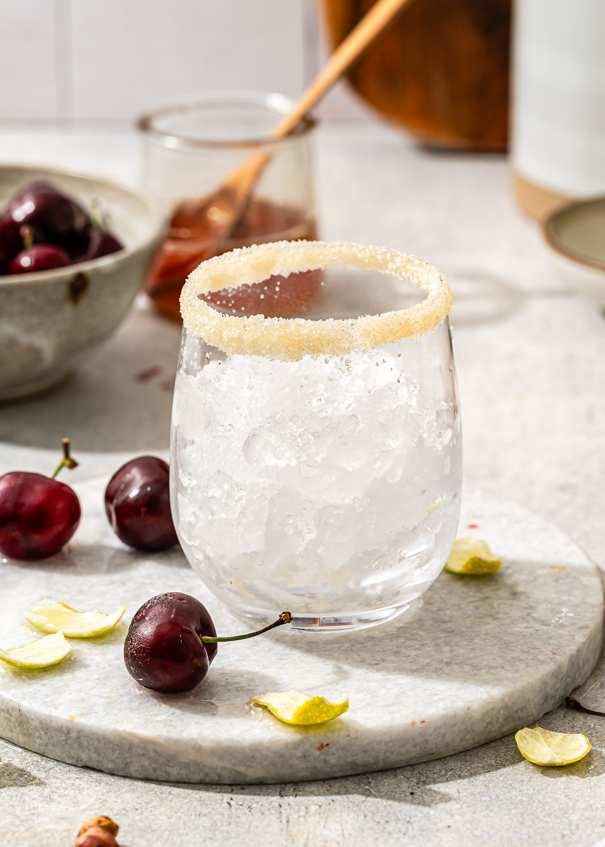 A stemless wine glass with a decorative sugar rim and full of ice.