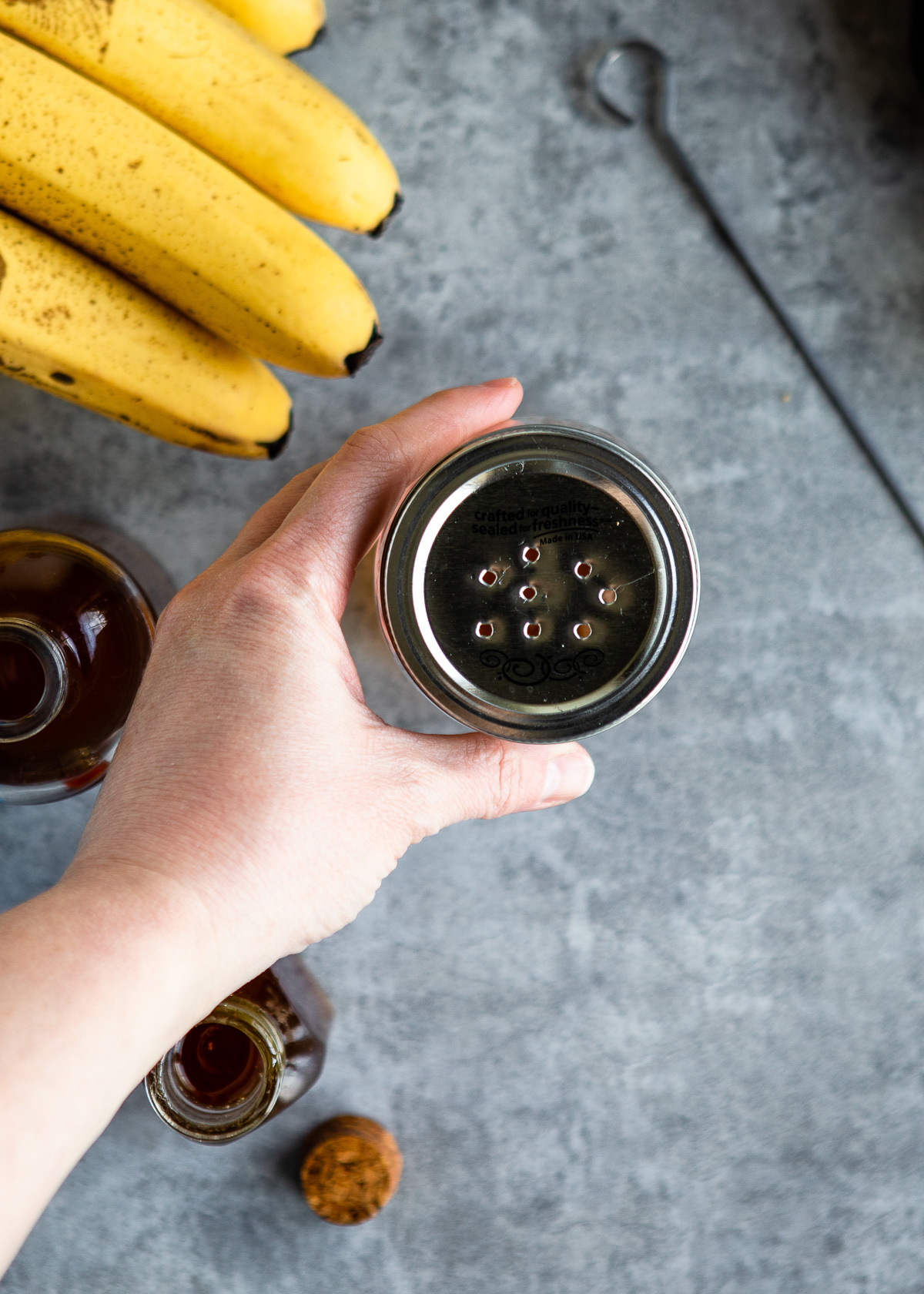 Perforated steel lid covering a mason jar.