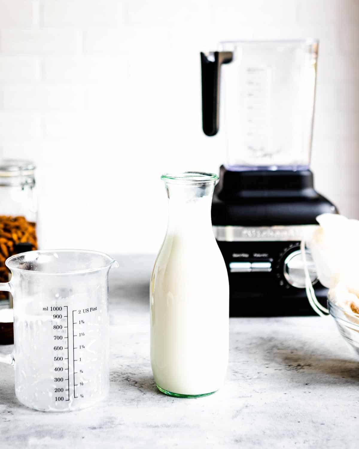 A bottle of homemade almond milk on a counter.