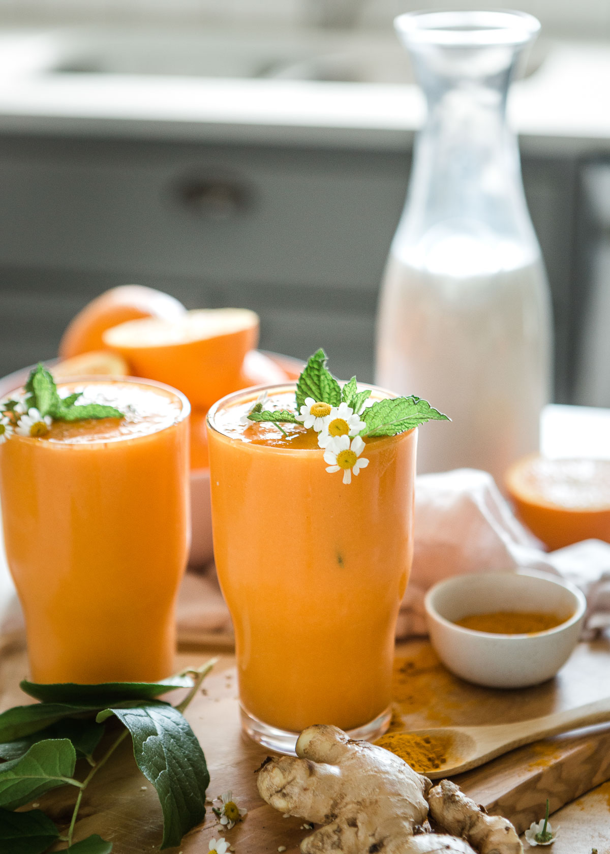 Two glasses of turmeric smoothies on a table