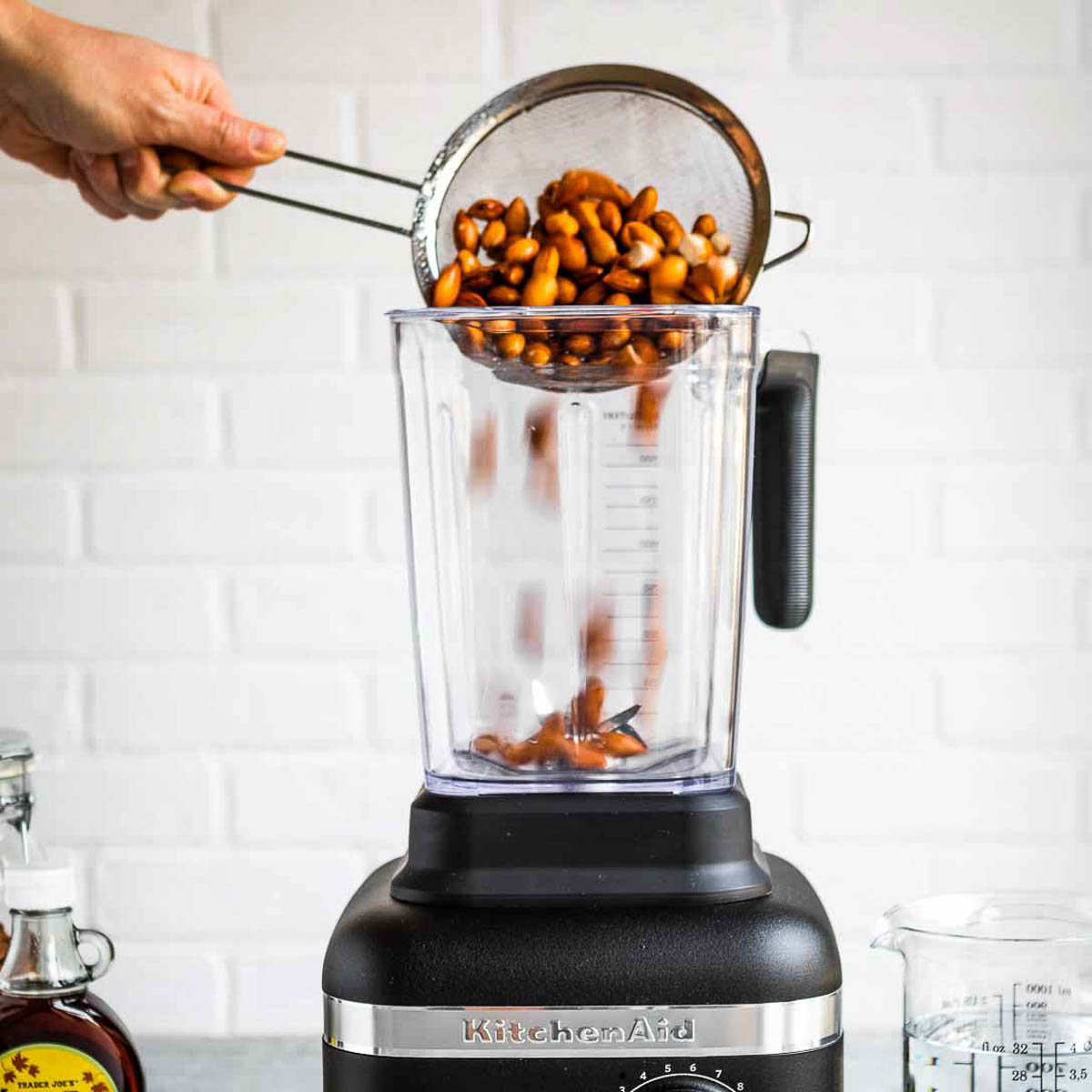 Pouring almonds into a blender
