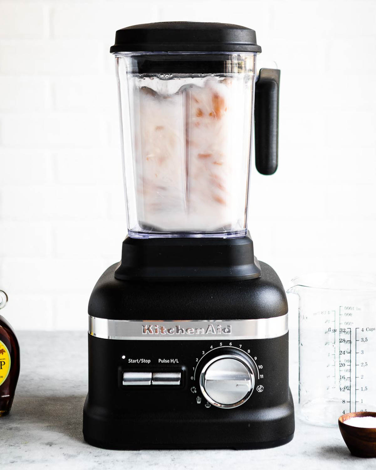 blending nuts and water in a black kitchenaid blender