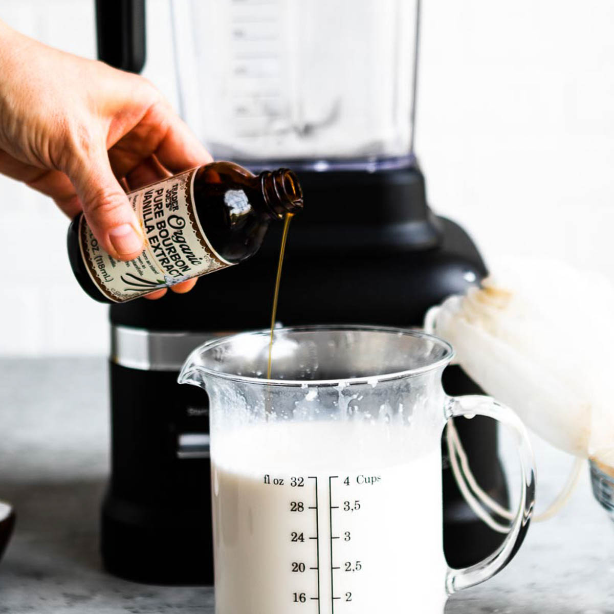 adding vanilla extract to a measuring glass full of homemade milk