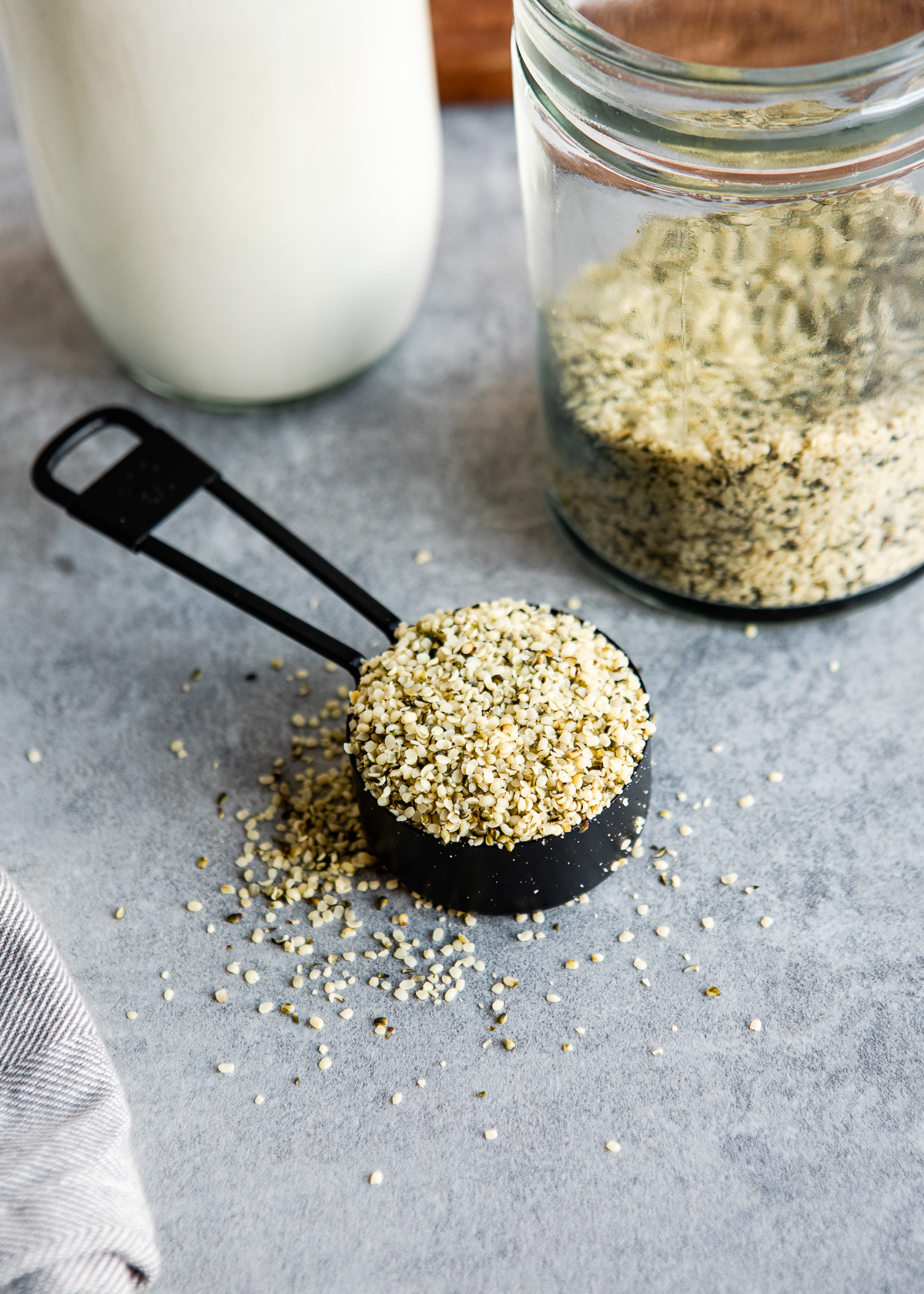 A black measuring cup with hemp seeds