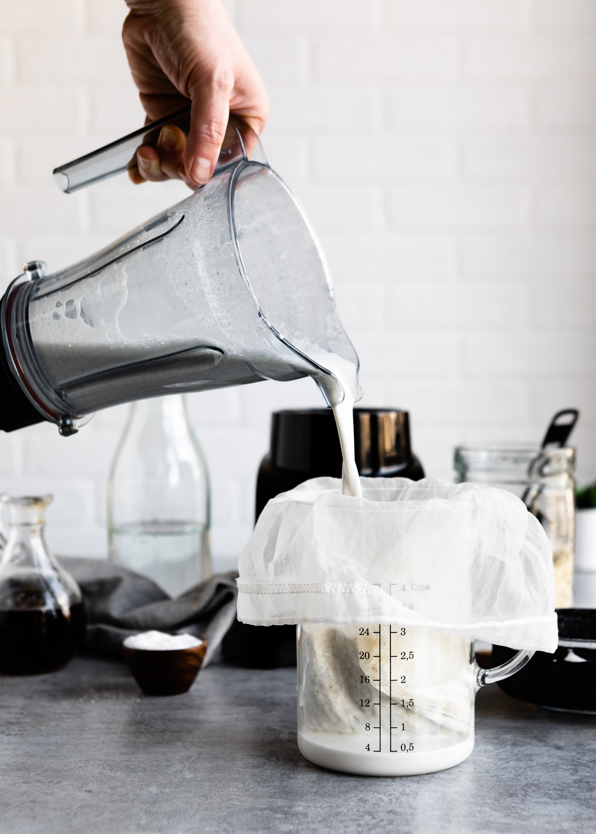 Pouring hemp milk recipe into cheesecloth. 