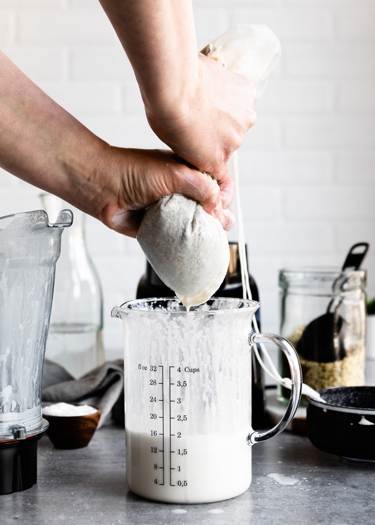 Squeezing hemp seeds through a cheesecloth bag to extract the hemp milk.