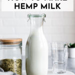 glass jar of hemp milk next to a jar of hemp hearts and short glasses.