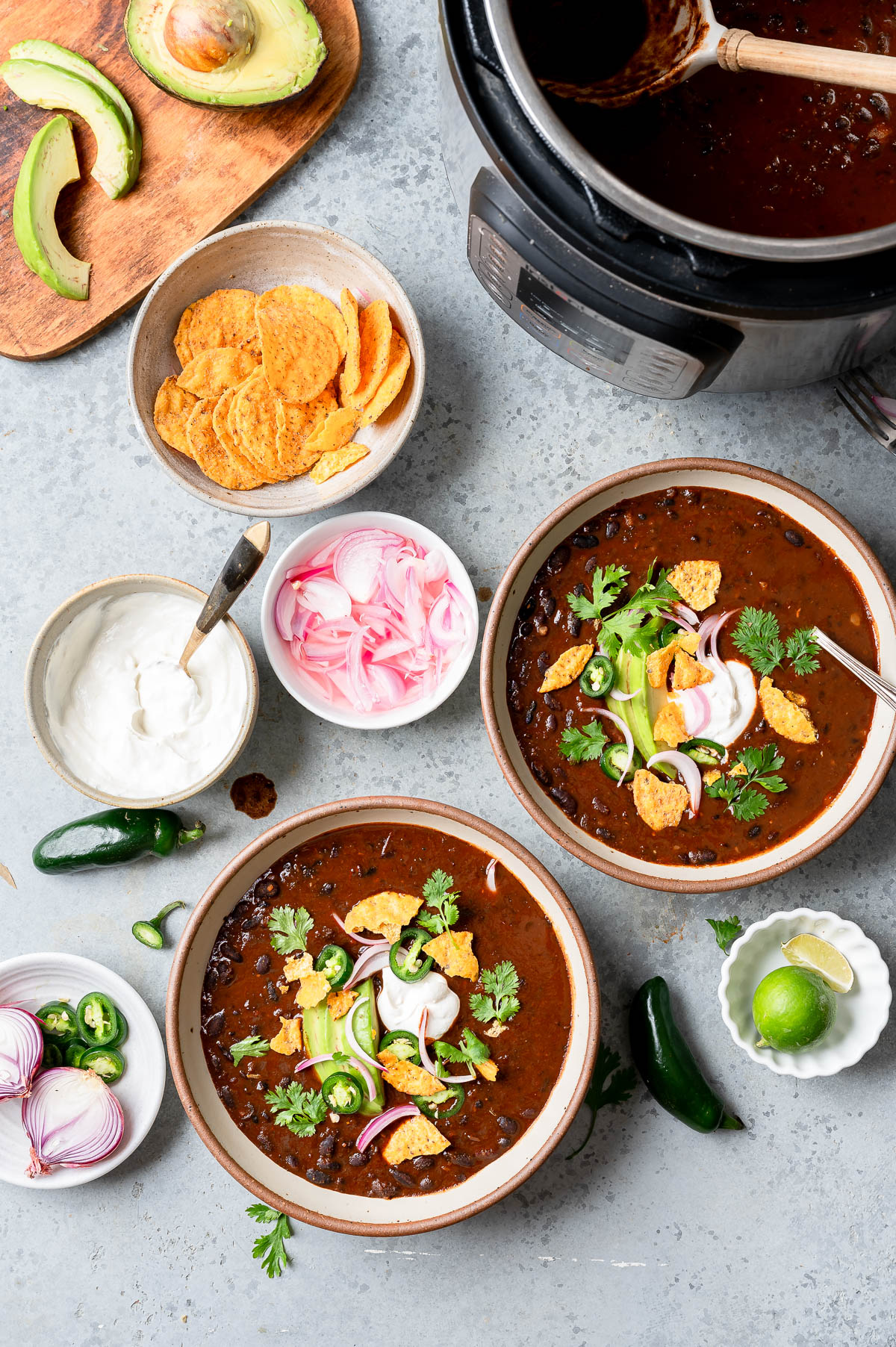 Black bean soups topped with onions, cilantro and tortilla chips