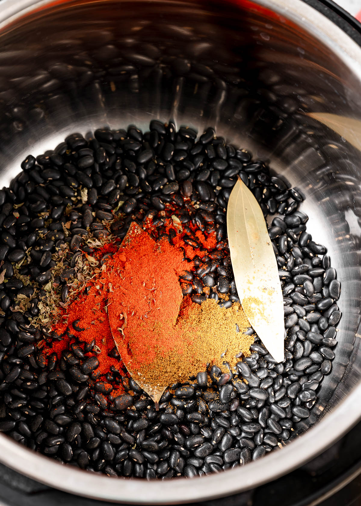 Black beans, spices, and bay leaves inside an  instant pot