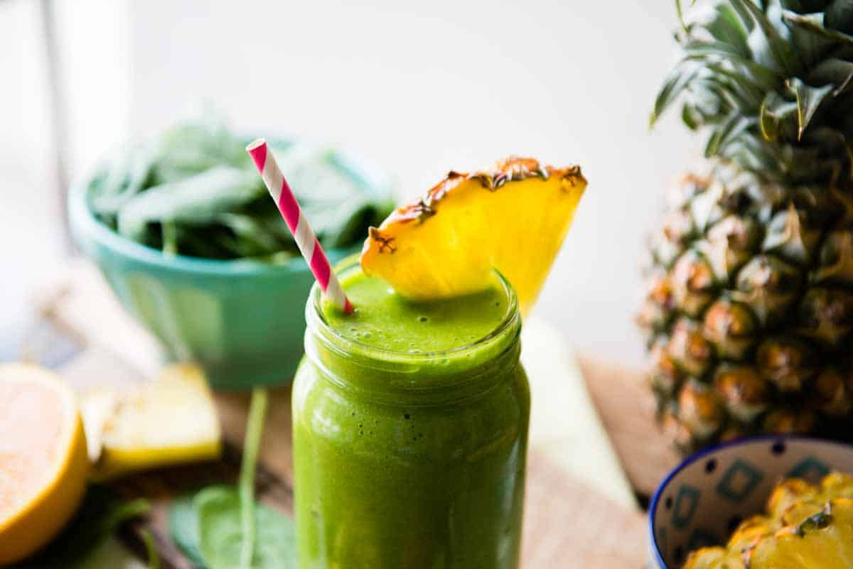 Green smoothie in mason jar with paper straw