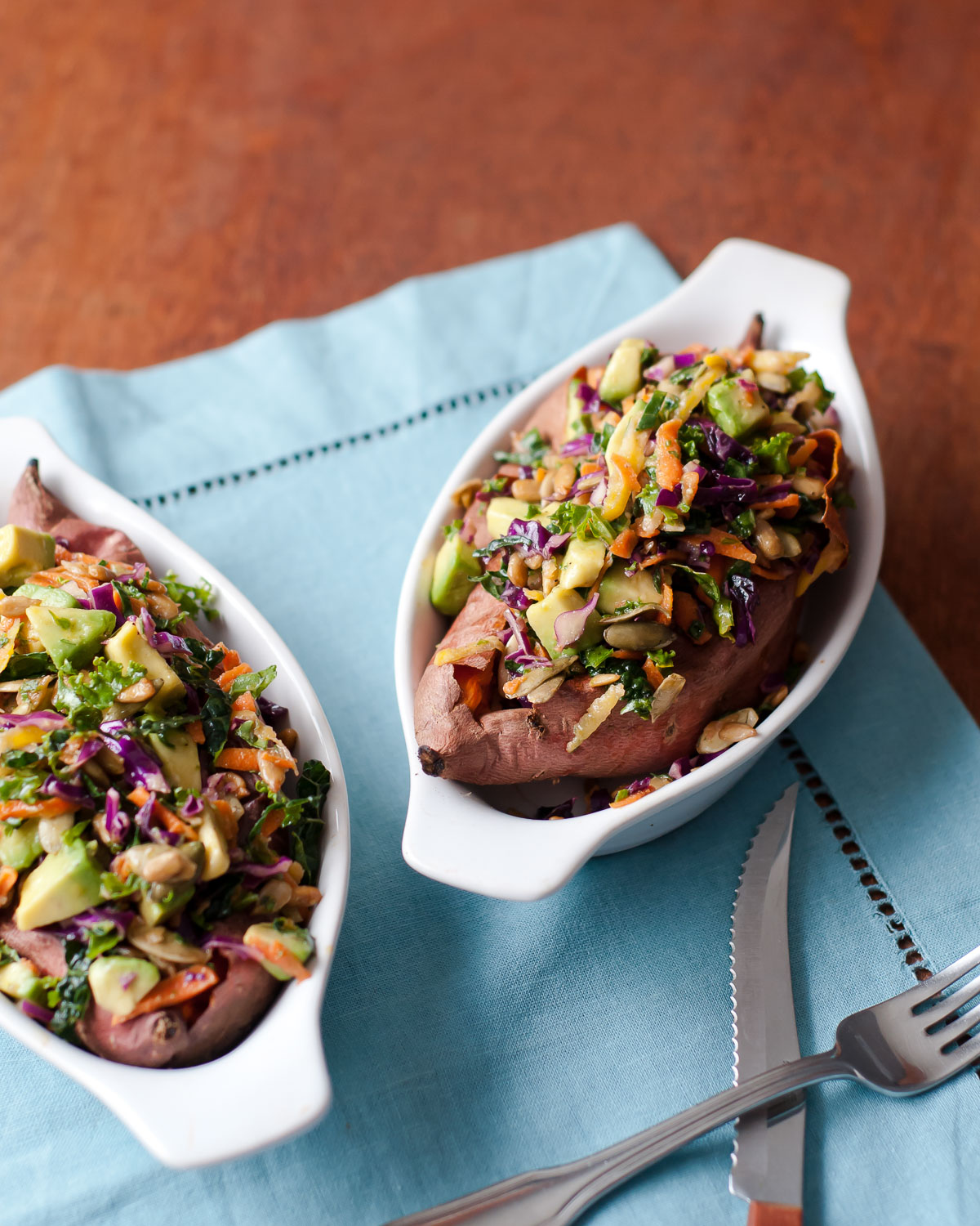 2 beautiful loaded sweet potatoes with kale slaw in fun gratin bowls, oven-baked to perfection.