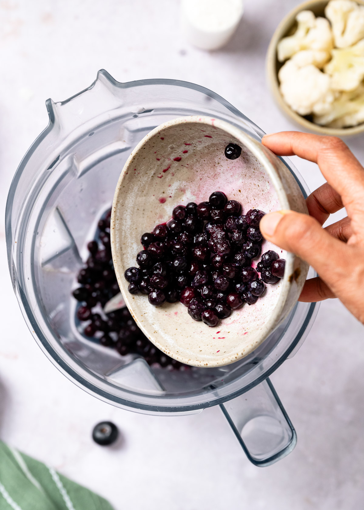 Adding blueberries to a blender