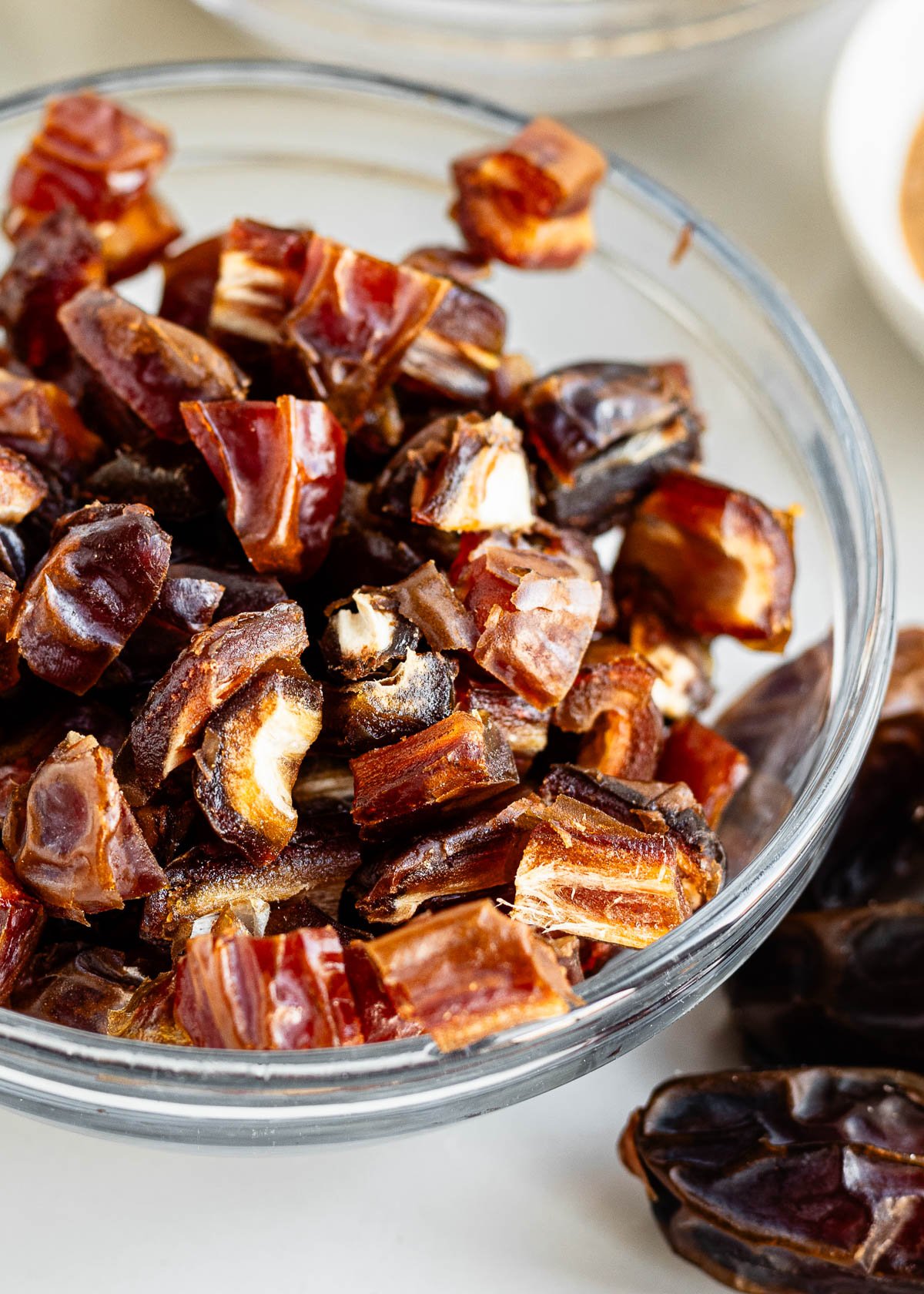 a glass bowl filled with chopped dates