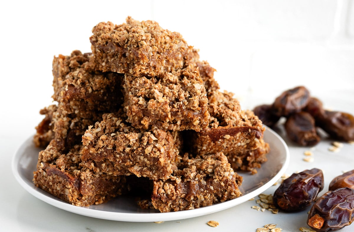 Old-fashioned date bars on a plate ready to eat with whole dates beside them