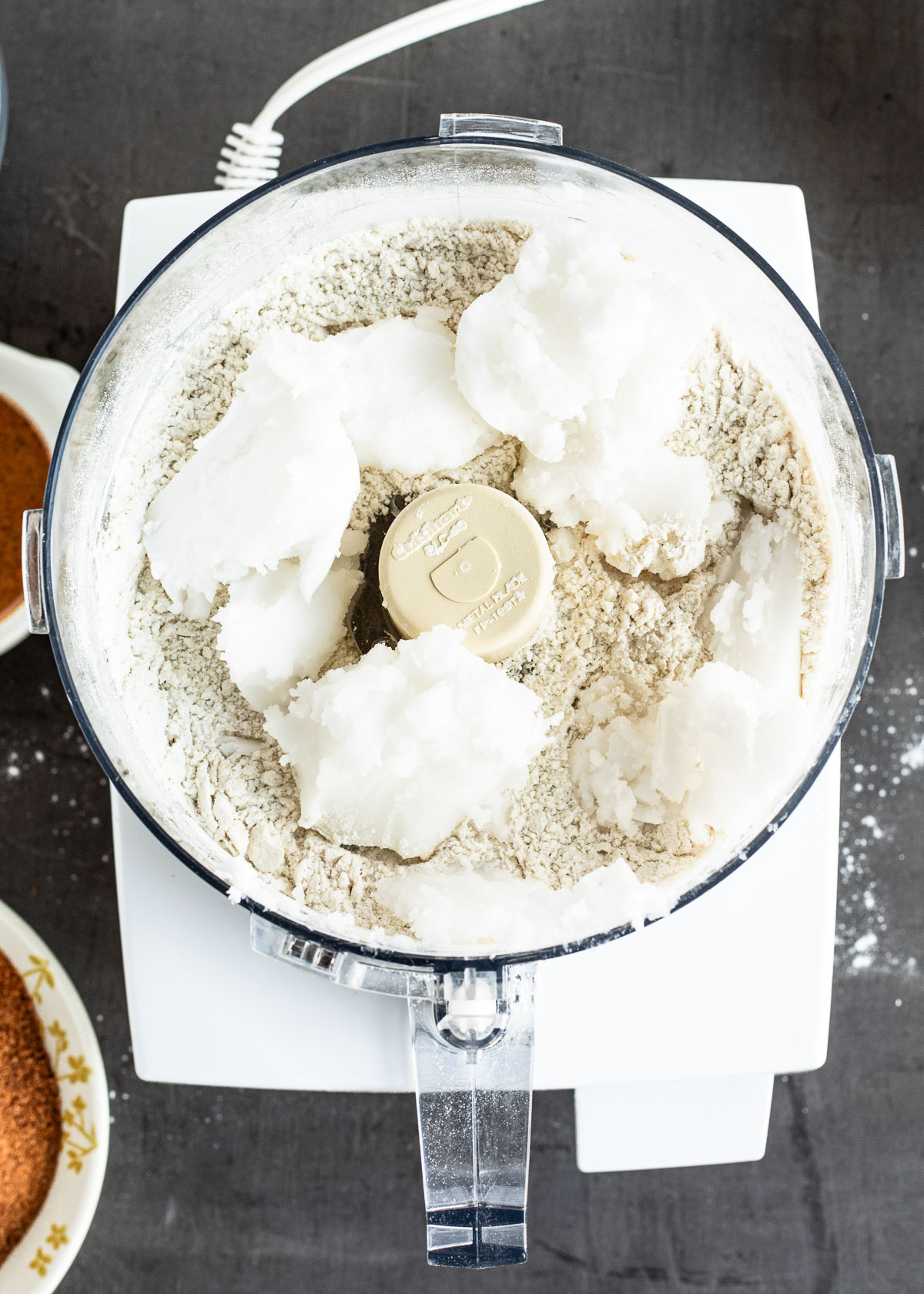 Spoonfuls of coconut oil in the dried flour mixture