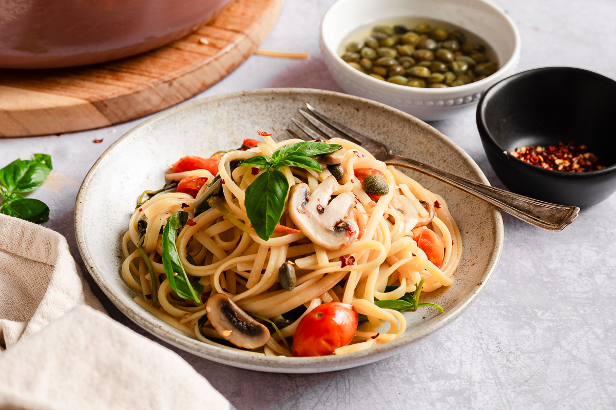 Vegan one-pot pasta on a plate, topped with basil leaves