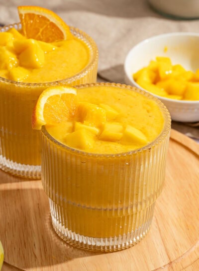 Refreshing mango orange smoothie with fresh fruit garnish.