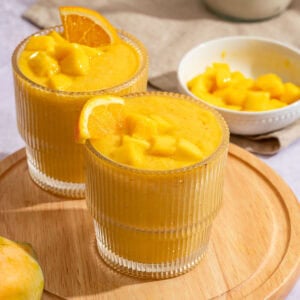 Refreshing mango orange smoothie with fresh fruit garnish.