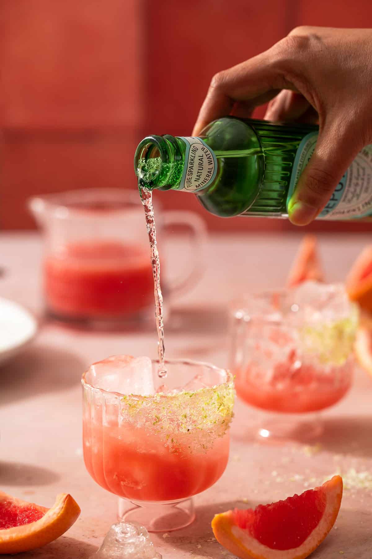 Pouring sparkling water over the drink