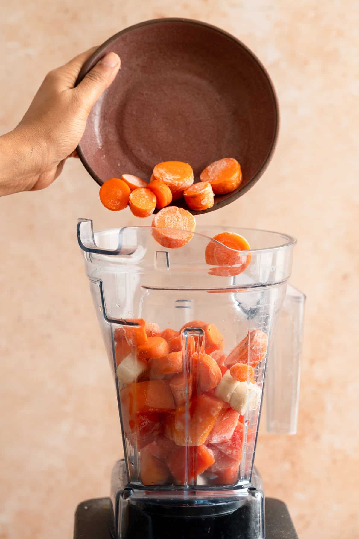 Fresh carrots being added to the blender