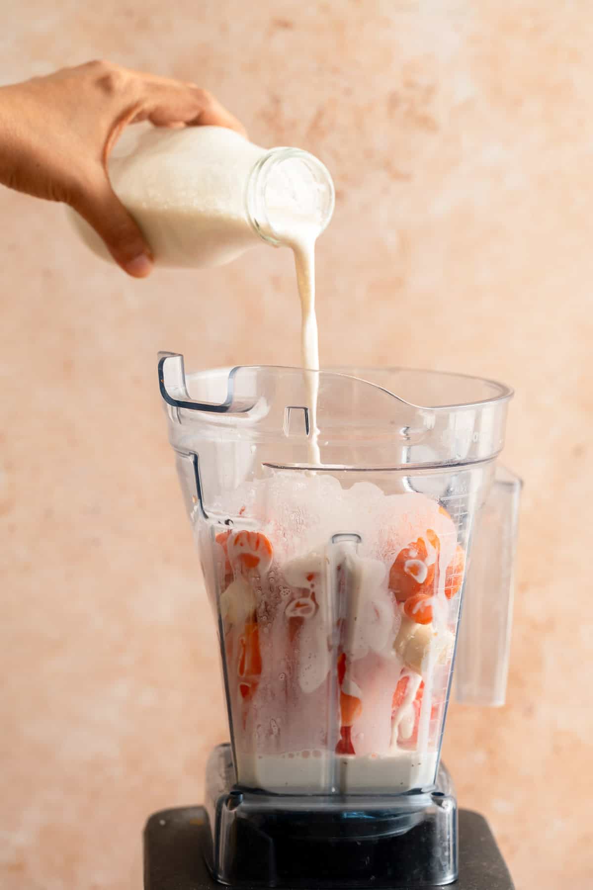 Adding coconut milk to the blender