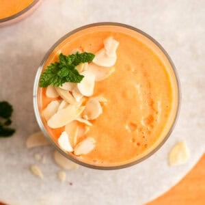 Creamy orange smoothie with white chocolate shavings and mint garnish.