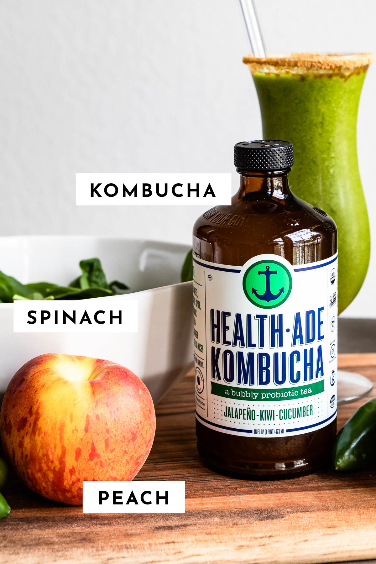 Labeled ingredients: kombucha bottle, fresh spinach (bowl), peaches