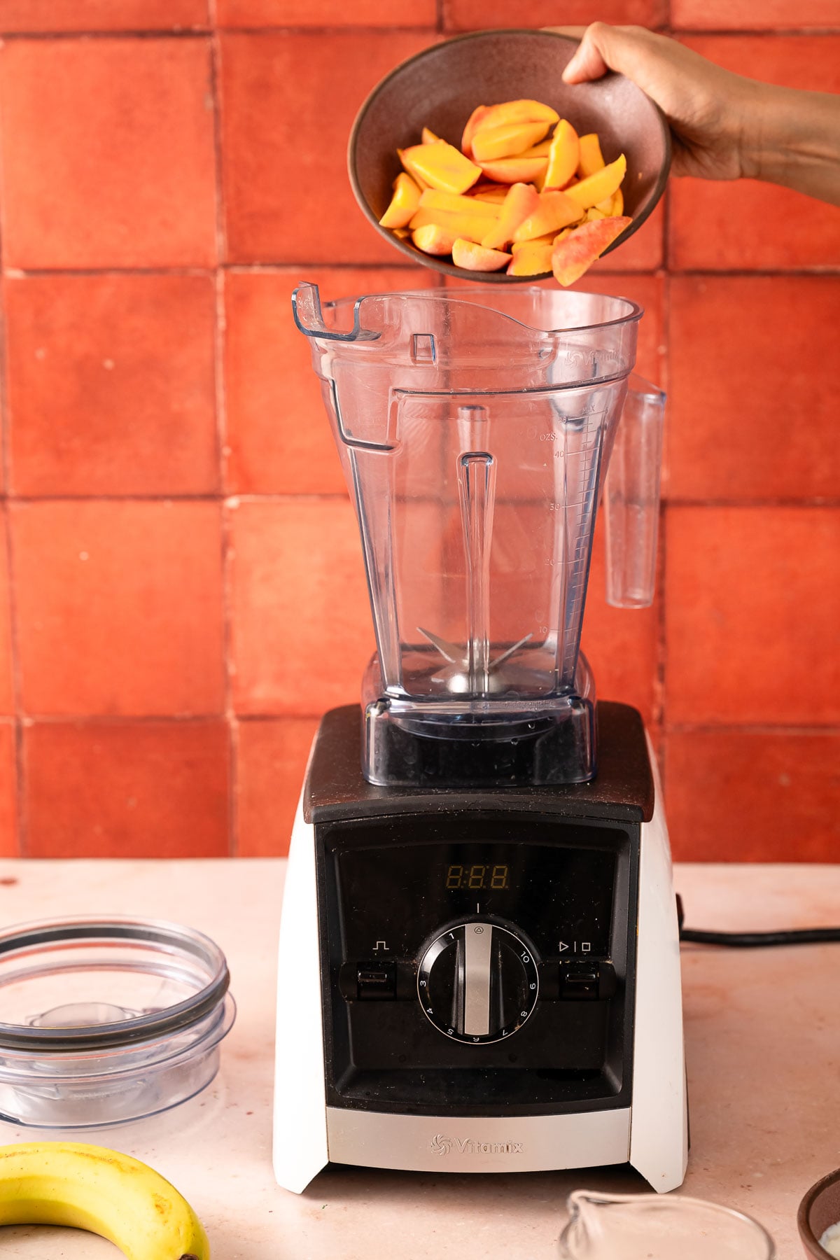 Adding frozen peaches to a blender
