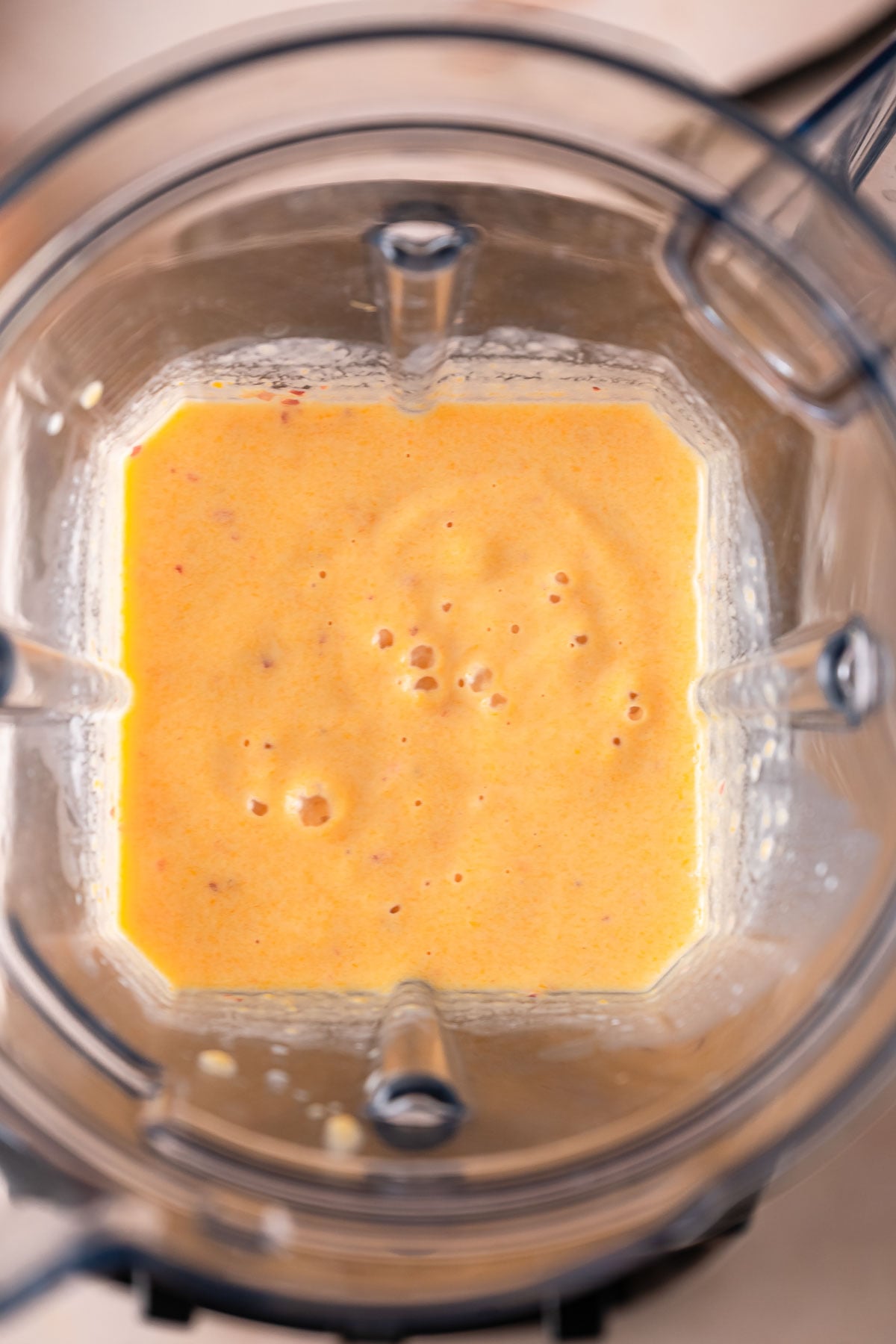 Blended peaches and cream smoothie ready to pour in a glass