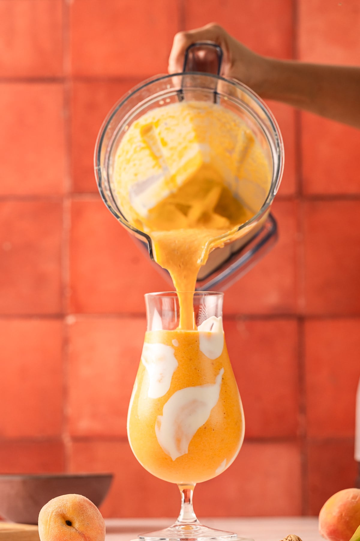Pouring peaches and cream smoothie in a glass