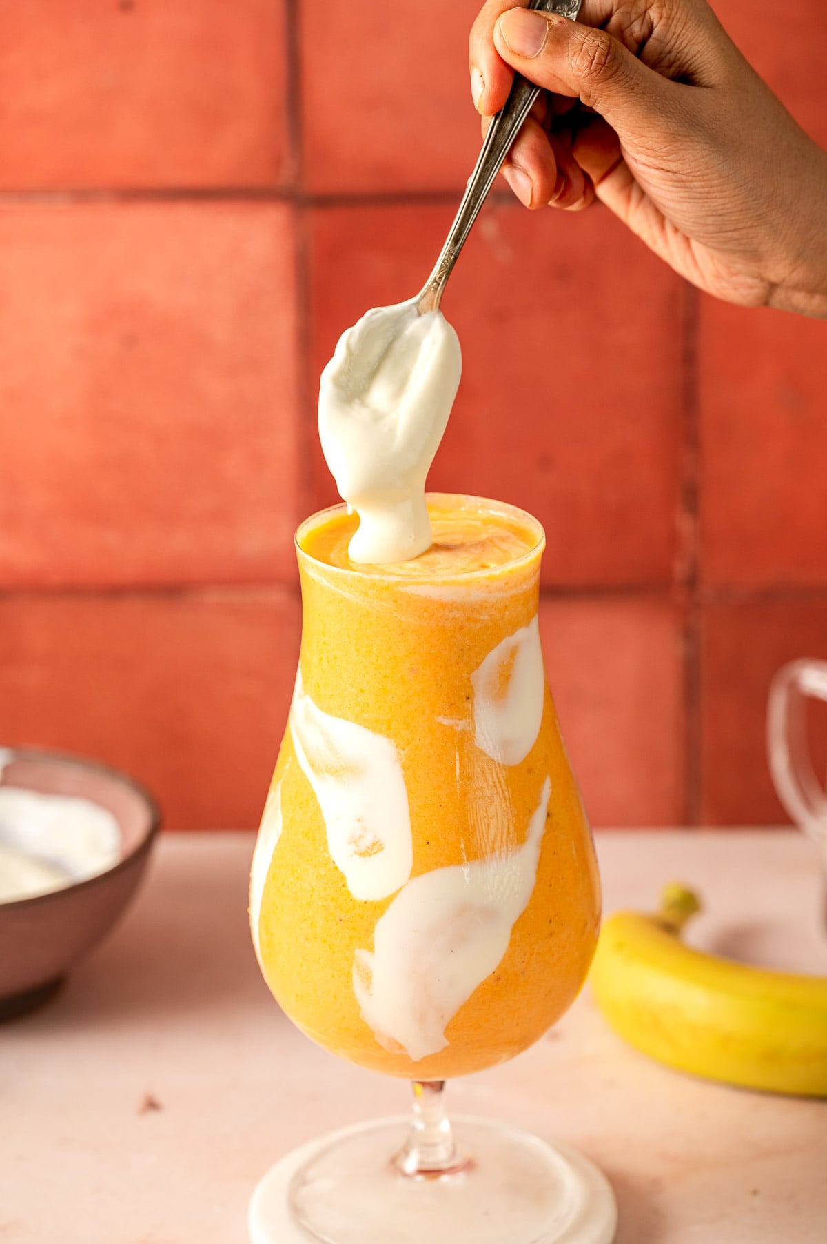 Topping peaches and cream smoothie with a dollop of Greek yogurt