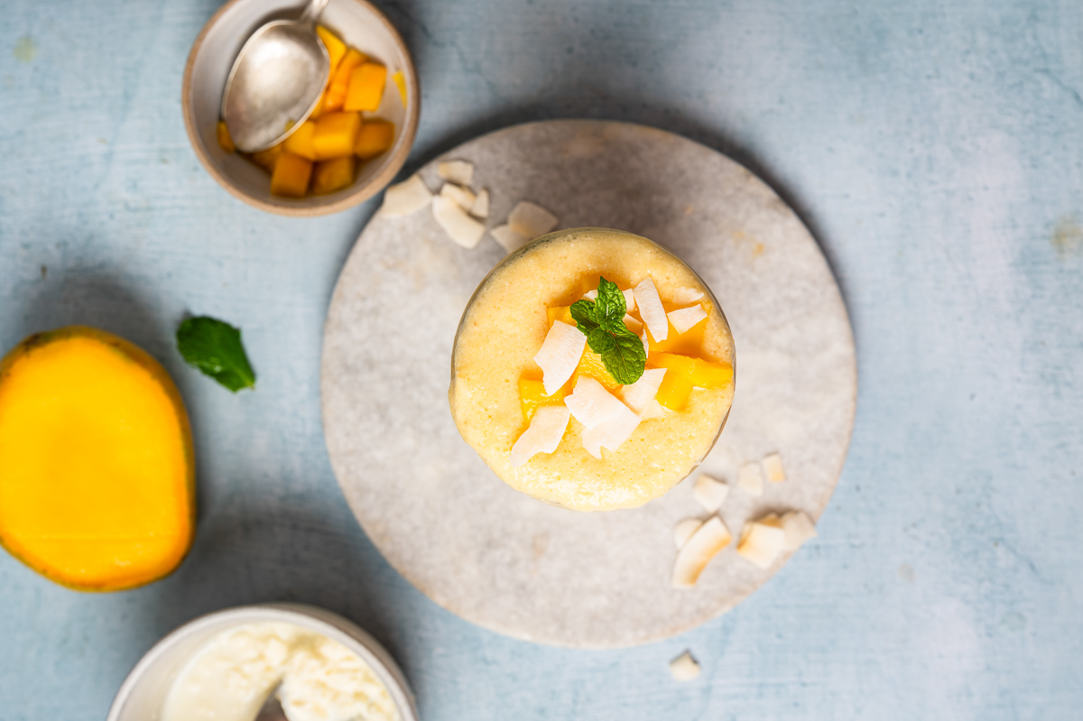 Pineapple cottage cheese smoothie with coconut shreds and mango chunks on top