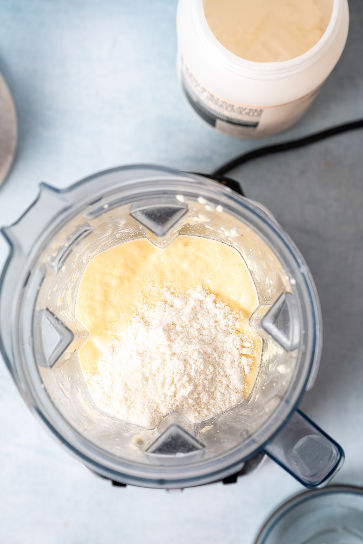 Pineapple cottage cheese smoothie in a blender with protein powder added