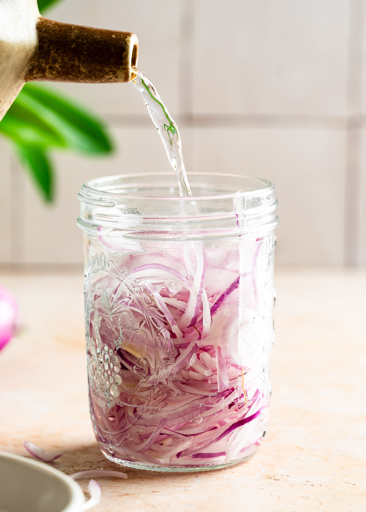 Pouring water into the jar of sliced onions