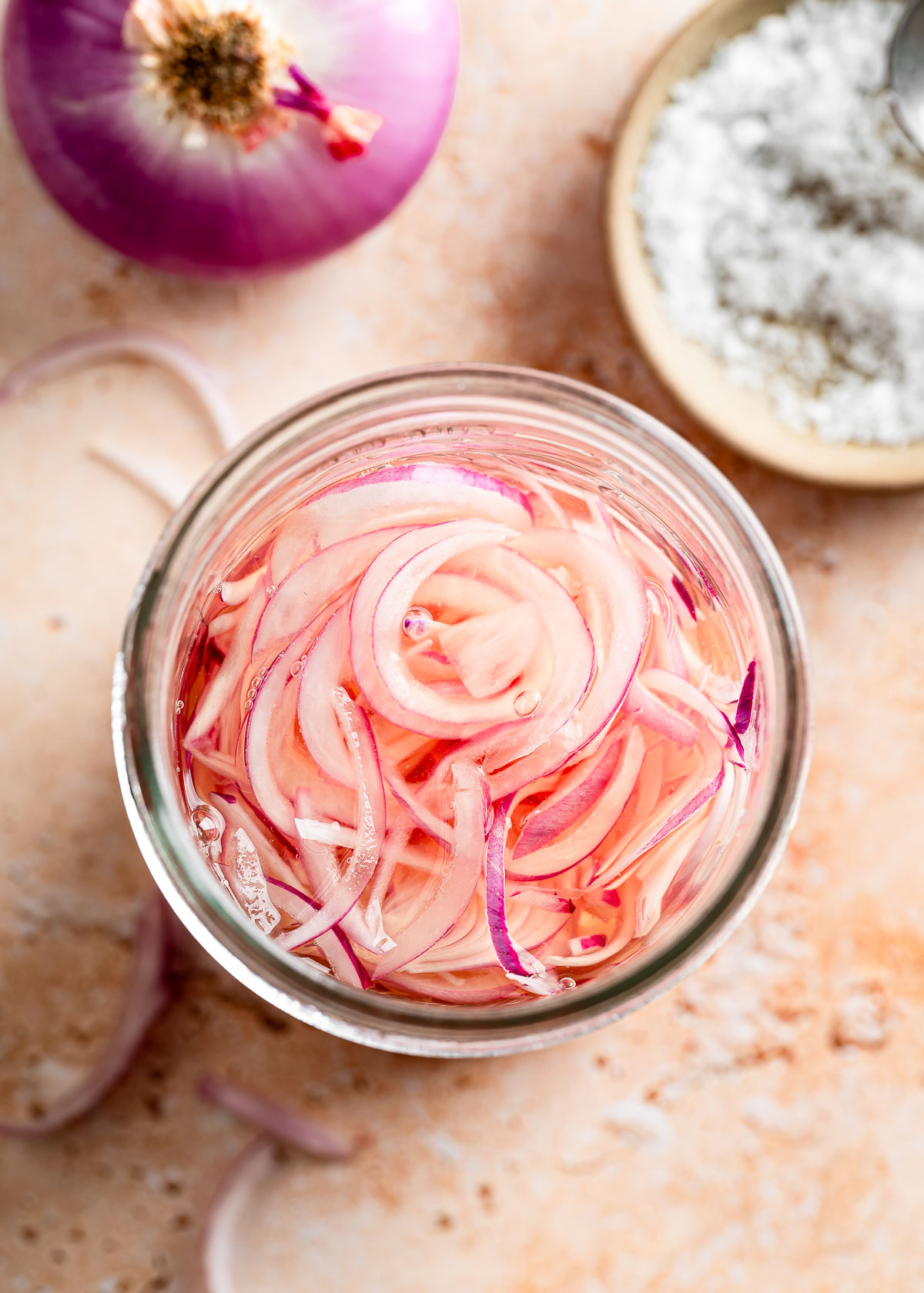 Thinly sliced red onions submerged in a water and vinegar mixture 