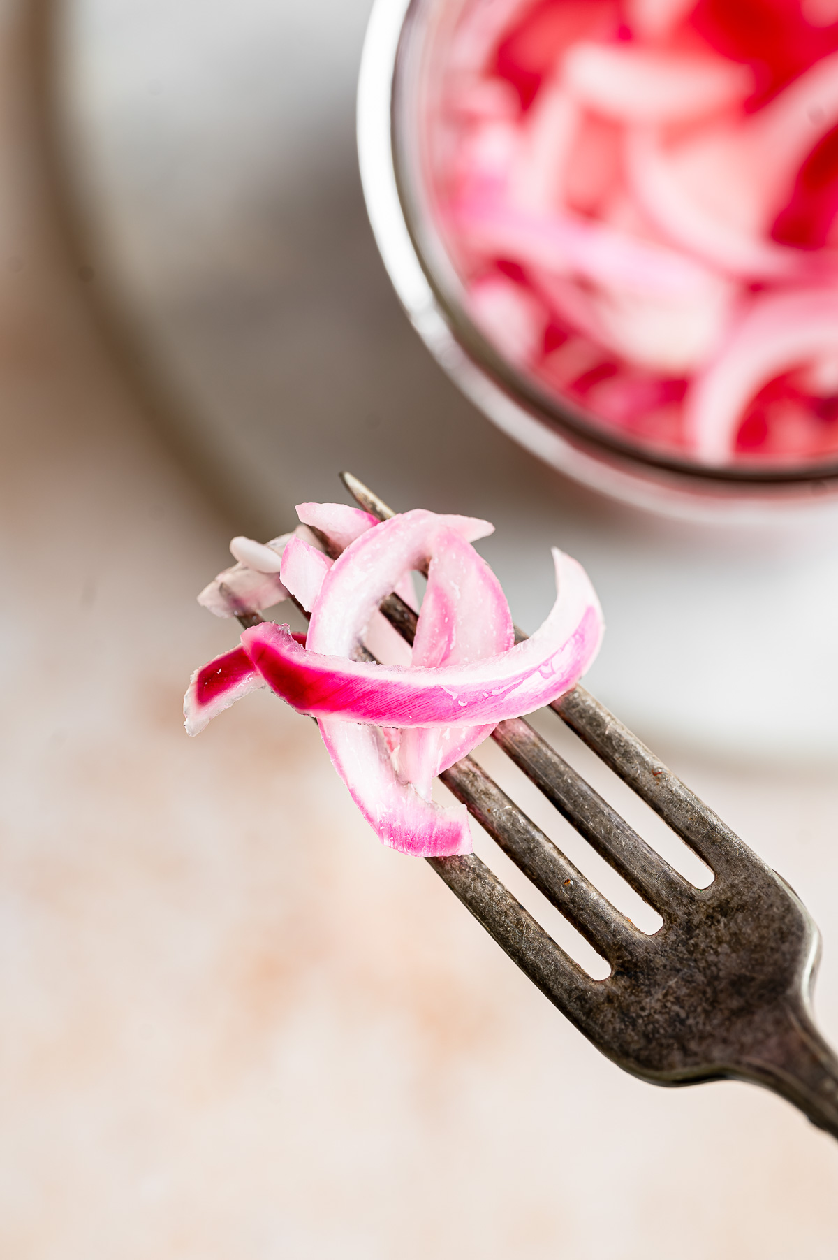 Vibrant pickled red onion slices on a fork