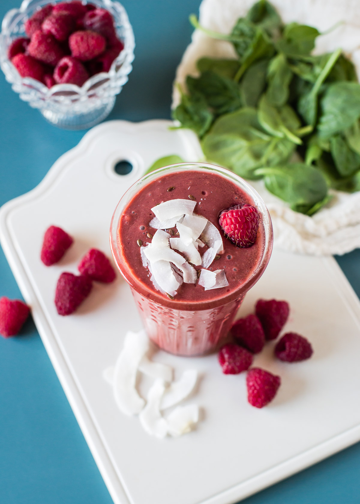 Vibrant pink raspberry smoothie, topped with coconut flakes