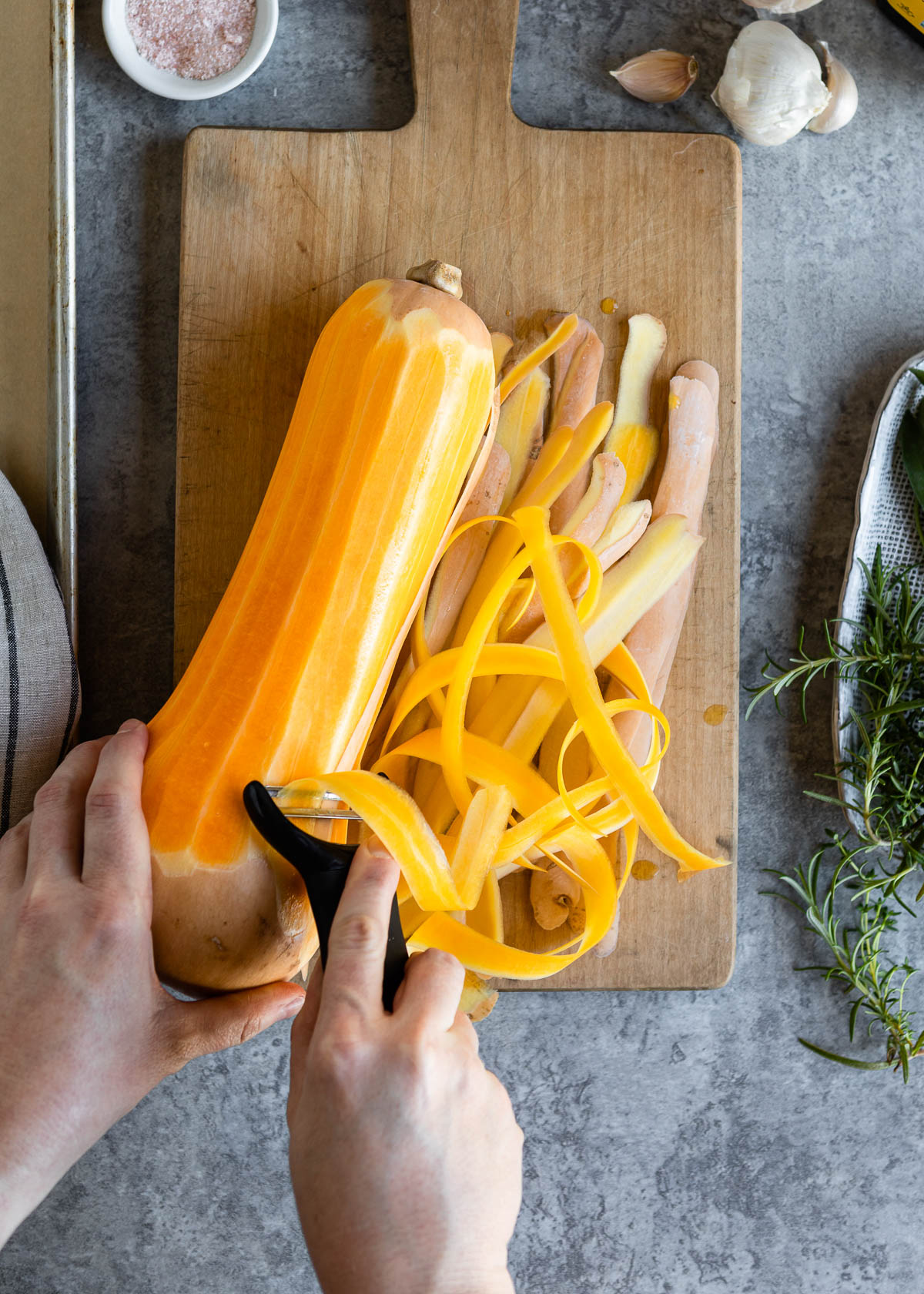 A person peeling butternut squash
