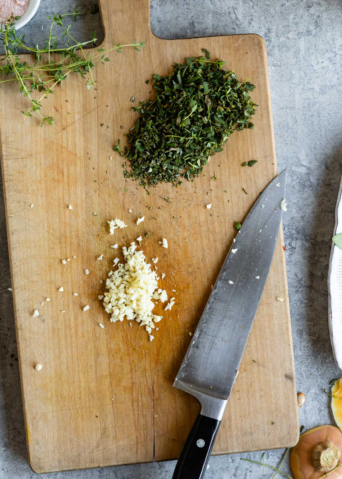 Chopped herbs and garlic on a cutting board