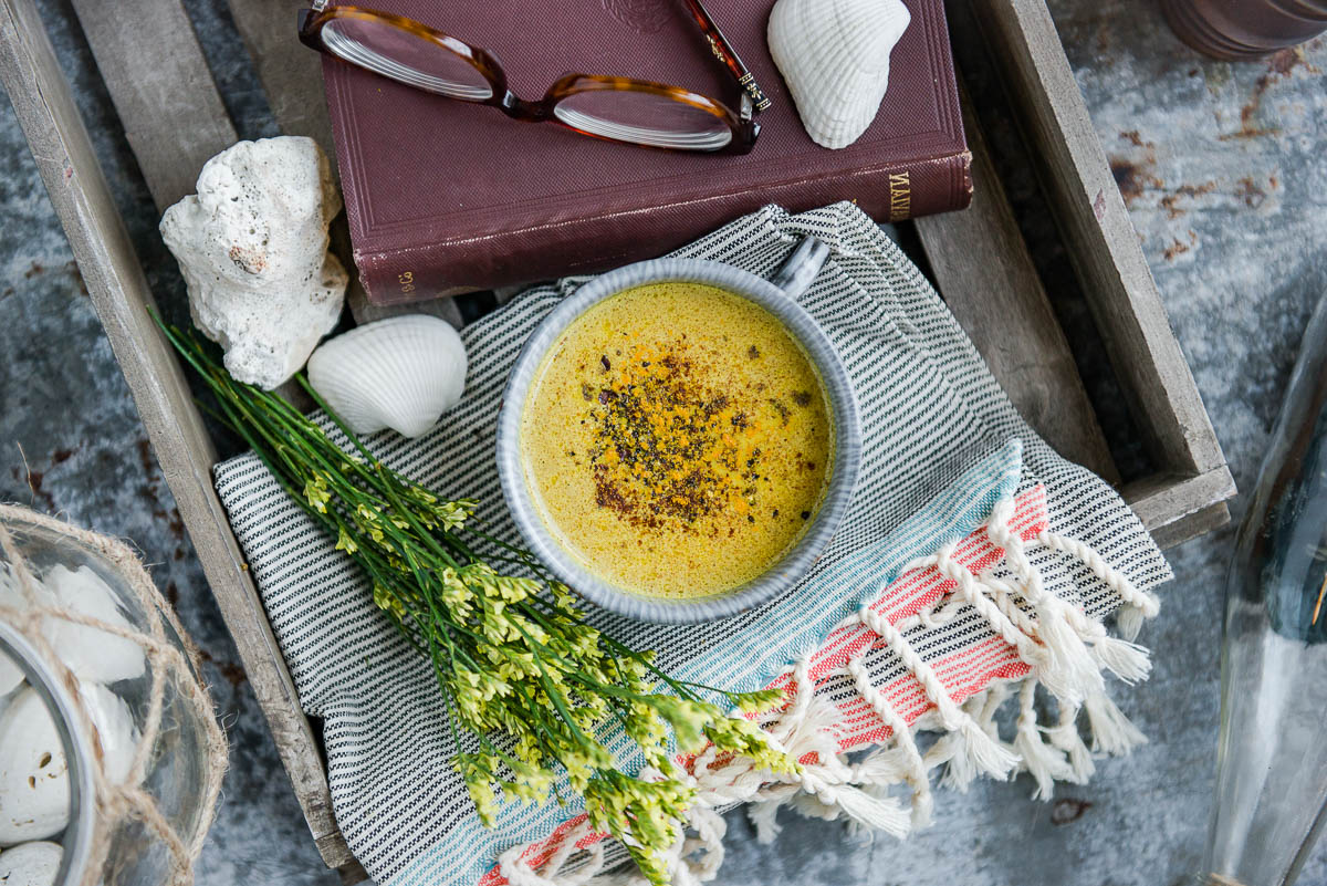 A cup of turmeric milk served warm in a ceramic mug