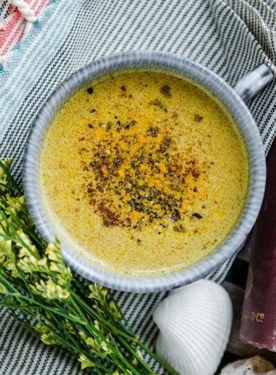 A warm cup of golden milk recipe topped with a sprinkle of cinnamon