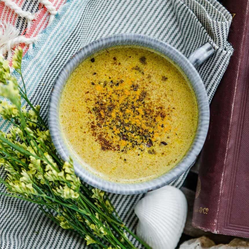 A warm cup of golden milk recipe topped with a sprinkle of cinnamon