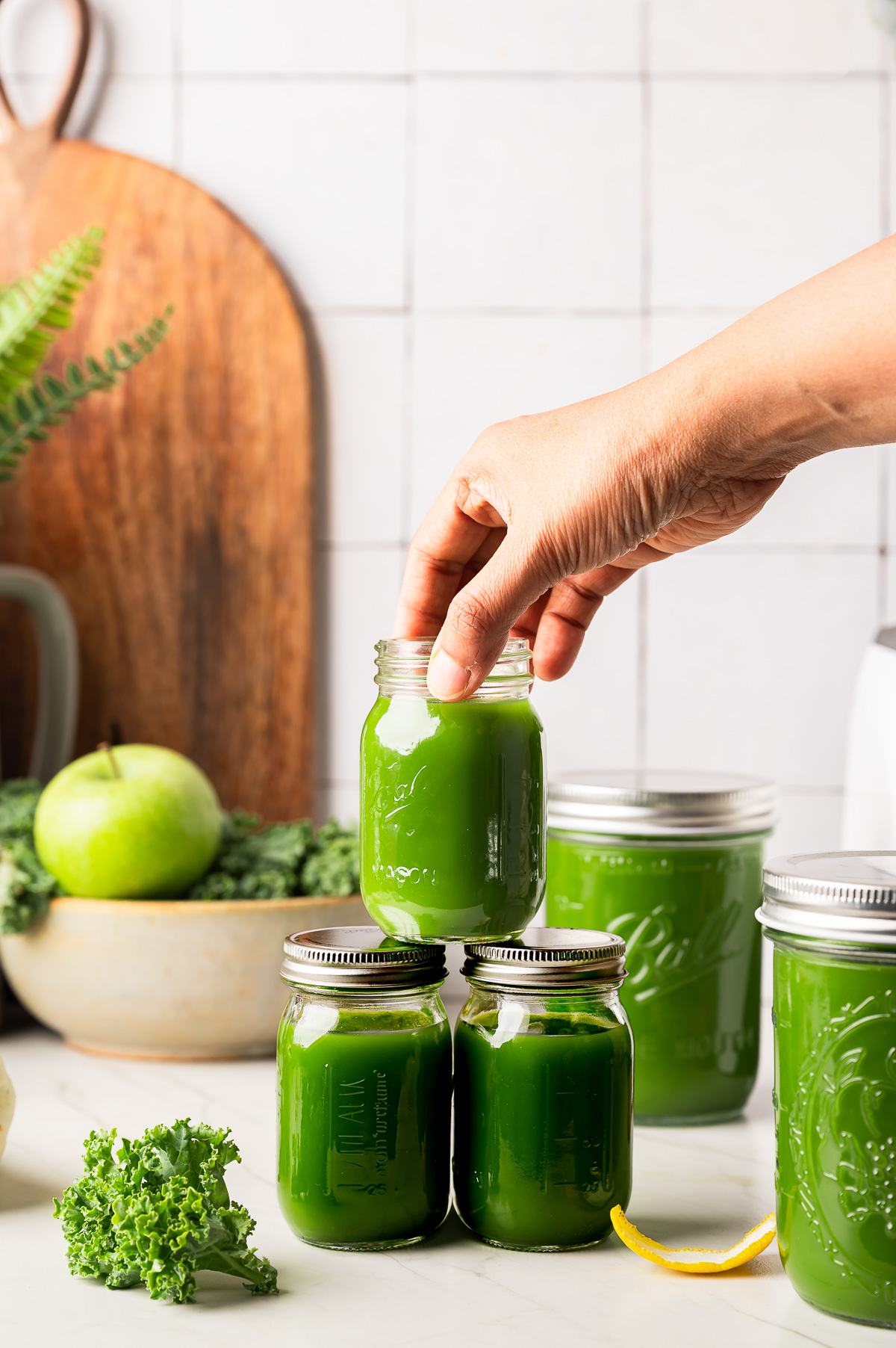 Sealed glass jars filled with fresh, vibrant green juice