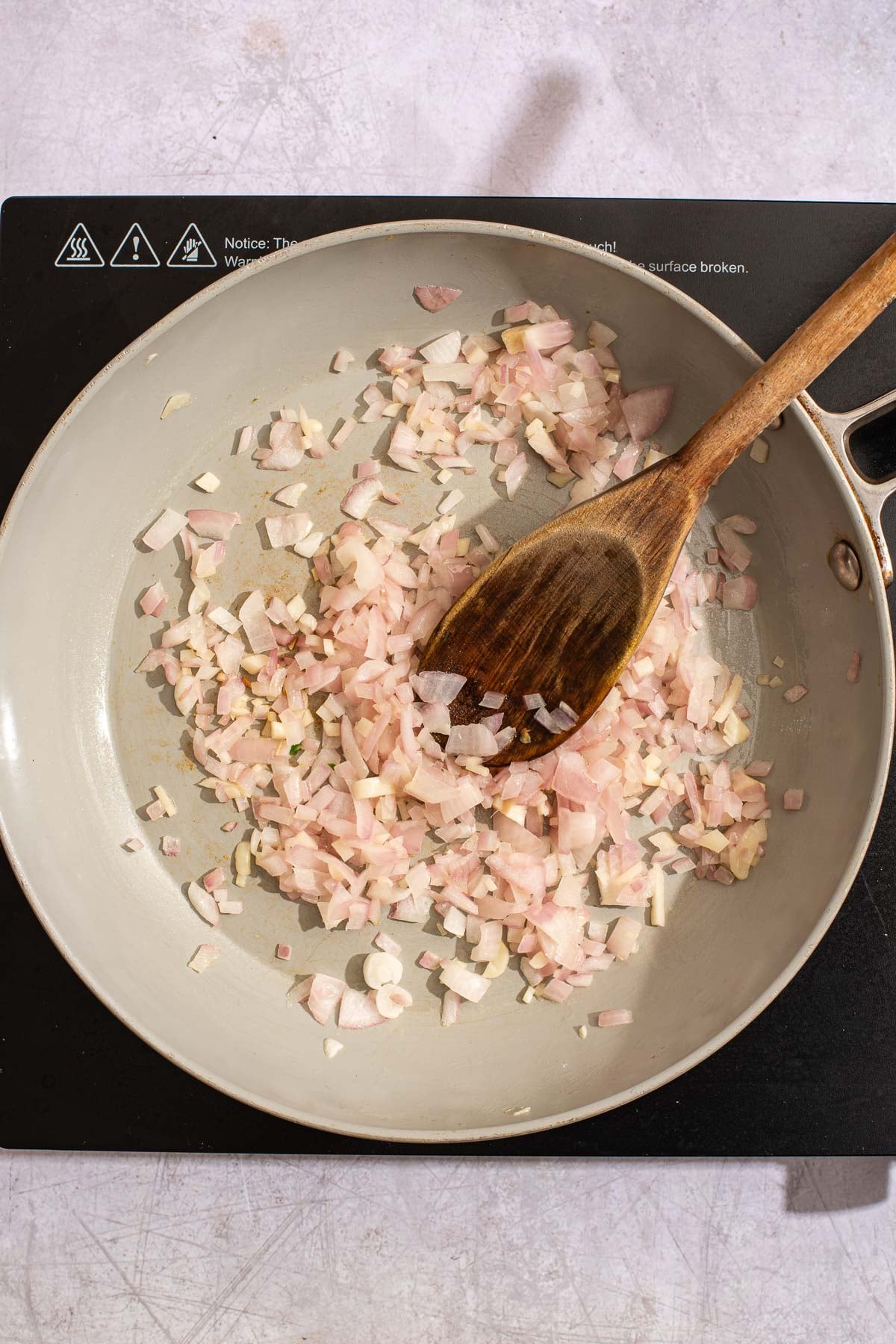 Garlic and diced onion sautéing on a skillet