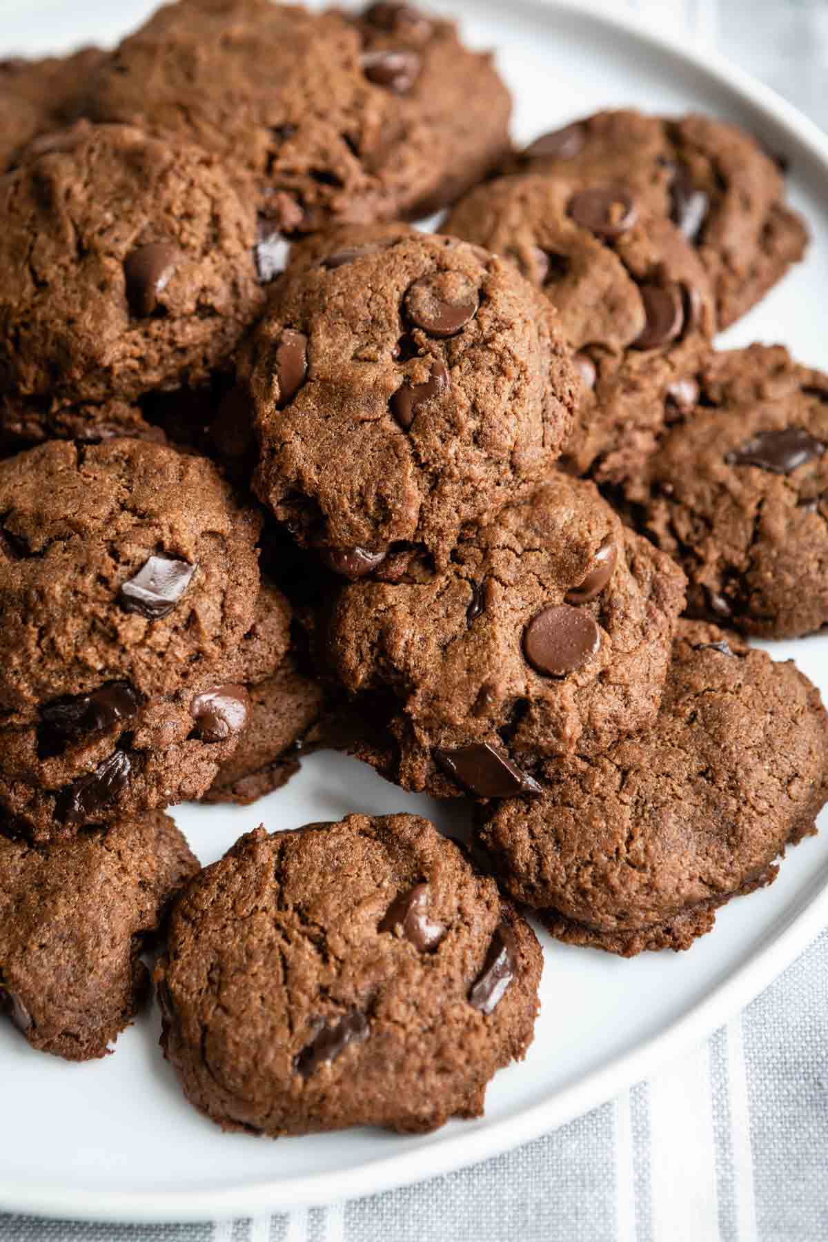 A white plate with ginger chocolate chip cookies piled on top